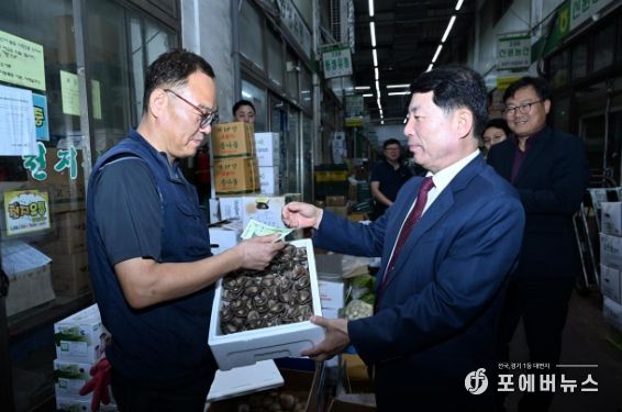 백경현 구리시장이 농산물 시장에서 상품을 직접 구매하고 현장 물가를 체험하고 있다.
