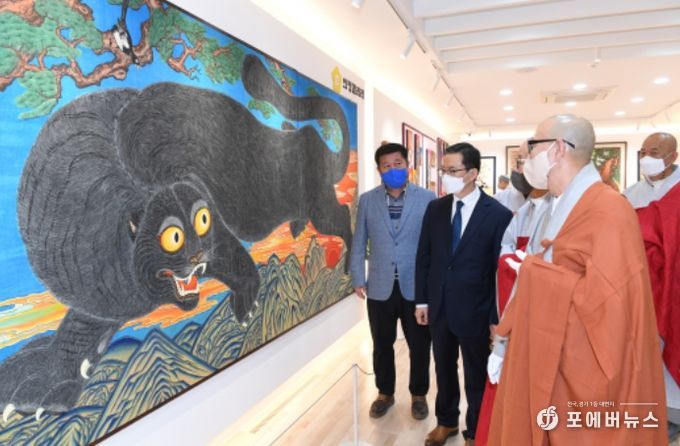 경공스님이 ‘흑범도’ 앞에서 정덕영 양주시의회 의장을 비롯한 민화전 개막식 참석자들에게 작품 설명을 하고 있다.