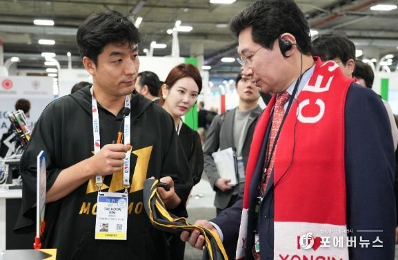 이상일 용인특례시장이 야구 투구 연습 도구 '자이로스피드'를 개발한 마고의 김태훈 대표로 부터 제품 설명을 듣고 있다.