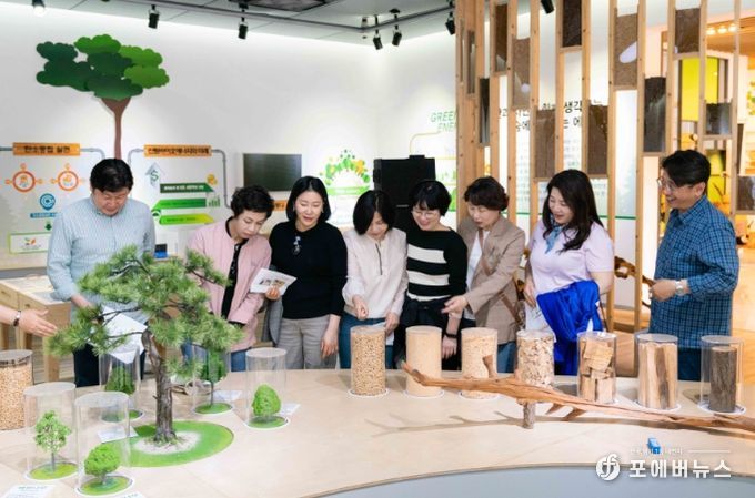 고산자연휴양림 산림바이오매스 홍보관에서 의원연구단체 회원들이 목재 연료칩의 제작 과정을 살펴보고 있다.