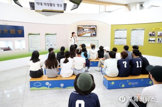 홍보관 견학담당자 설명을 듣는 어린이들