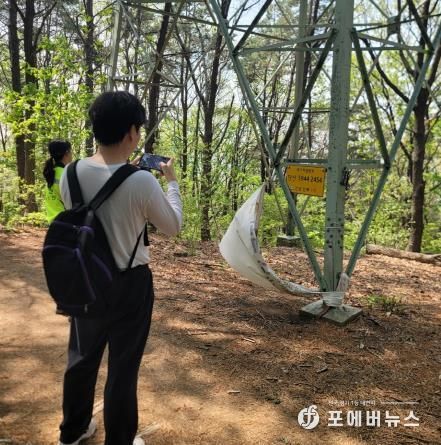 수원시 관계자가 국가지점번호판을 조사하고 있다.
