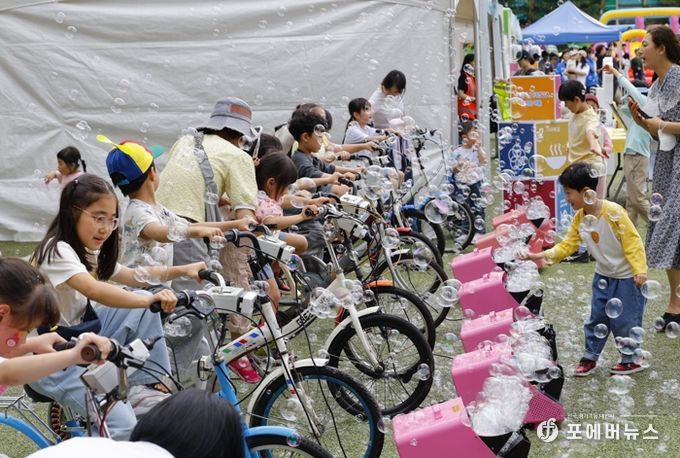 17일 우장산 축구장에서 열린 ‘2025 우장산 그린페스타’를 찾은 아이들이 자전거 발전기로 비눗방울을 만들고 있다.