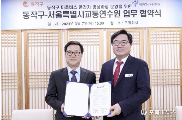 박일하 동작구청장(오른쪽)이 지난해 3월 고홍석 서울시 교통연수원장(왼쪽)과 업무협약을 체결한 후 기념 촬영하고 있다.