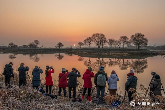 남도풍경연구소 소속 사진작가들이 동섬에서 떠오르는 해를 촬영하고 있는 모습.(사진 제공-나주시)