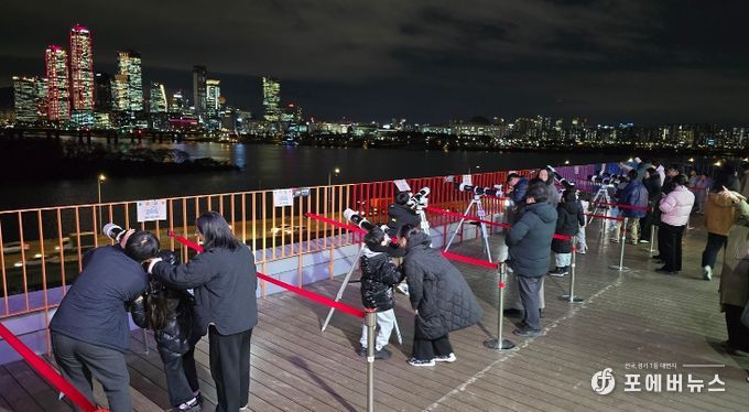마포365천문대 옥상 천체관측실에서 망원경으로 달을 관측하는 마포구민 가족들